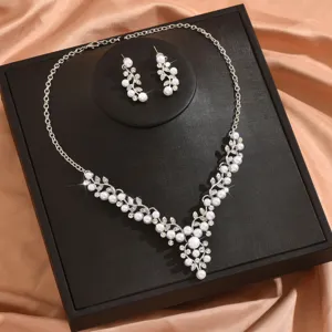 Vista dettagliata di un elegante set di collana e orecchini di perle e strass su scatola.