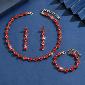 Primo piano sui dettagli del set di gioielli in cristallo rosso, maglie di catena dorate lucide.