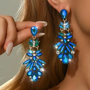 Primo piano dettagliato di orecchini pendenti in cristallo blu con strass scintillanti.