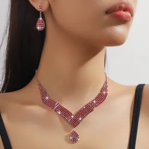 Primo piano dettagliato di elegante set di collana a V in strass di cristallo rosso e orecchini.