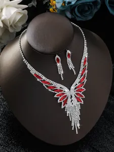 Primo piano dettagliato di un set collana e orecchini in cristallo rosso con strass luminosi.