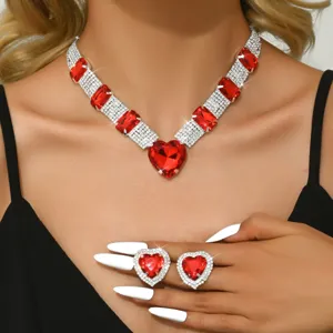 Dettaglio ravvicinato di lussuosa collana in cristallo rosso e orecchini a cuore coordinati e luminosi.