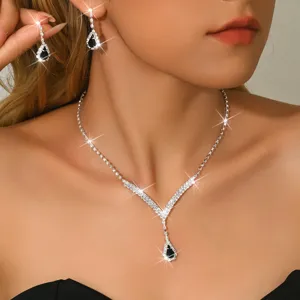 Primo piano di collana scintillante di strass e orecchini a goccia set di gioielli eleganti