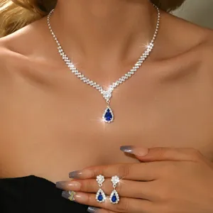 Dettaglio set collana e orecchini in cristallo blu a goccia per abito da sposa donna.