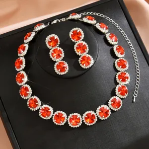 Primo piano dettagliato di collana e orecchini abbinati in cristallo rosso e strass.