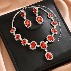 Dettaglio set collana e orecchini in cristallo rosso, gioielli da sposa con strass luminosi.