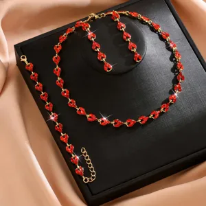 Dettaglio del set collana orecchini bracciale in cristallo rosso con pietre lucenti.