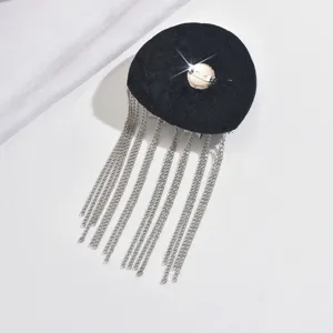 Detailed view of black velvet tassel shoulder epaulet costume accessory with metallic chains.