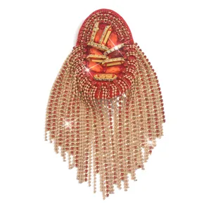 Detailansicht der luxuriösen Strass Quasten Schulterklappe mit funkelndem roten Schmuck.