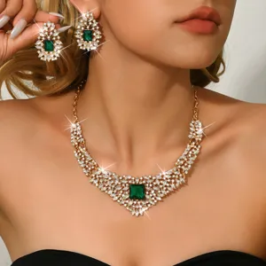 Luxury green crystal necklace and earrings set closeup, vintage gold tone rhinestone jewelry.