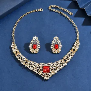 Vintage gold crystal necklace and earrings set with bold red gemstones and clear rhinestones.