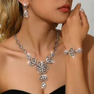 Detallado primer plano del conjunto de joyas de collar, pendientes y pulsera de flores.
