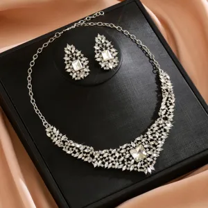 Close-up detail of luxurious silver crystal leaf statement necklace and earrings set sparkle.