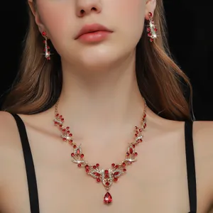 Dettaglio in primo piano della parure di gioielli con collana e orecchini di cristalli rossi.
