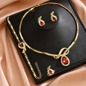 Set di gioielli collana orecchini bracciale anello dorato con pietra rossa brillante.