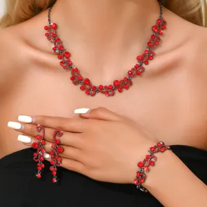 Elegante set di gioielli con strass rossi che include collana, orecchini e bracciale.