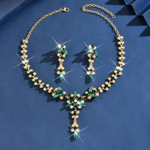 Elegante juego de joyas nupciales doradas con piedras de cristal verde y brillantes estrases.
