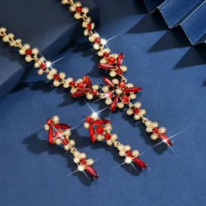 Primer plano detallado de la elegante parure de collar y pendientes con cristales rojos y dorados.