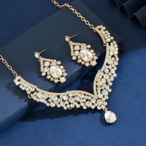 Detail shot of luxury gold crystal rhinestone statement necklace and matching earrings set.