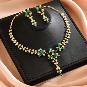 Elegante conjunto de joyas de collar y pendientes de cristal verde y estrás dorado.