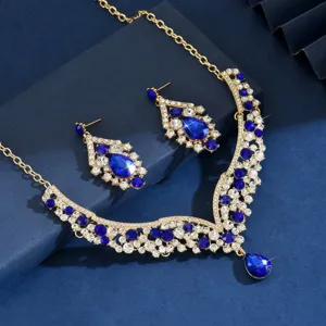 Close-up details of the luxurious gold-tone crystal rhinestone and sapphire blue jewelry set.