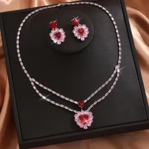 Elegante set di gioielli da sposa con collana e orecchini di zirconi brillanti e cristalli rossi.