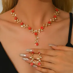 Set di gioielli con collana e orecchini floreali in cristallo rosso dorato vista dettagliata.