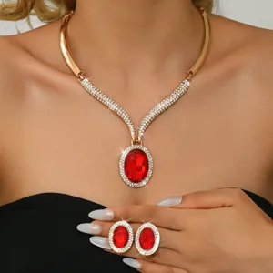 Dettagli in primo piano della collana e degli orecchini dorati con pietre rosse brillanti.