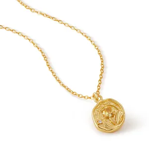 Detalle de collar con colgante de oro, dije redondo irregular con circonita amarilla brillante.