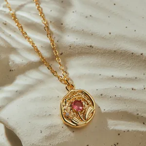Gros plan détail d'un collier pendentif rond irrégulier géométrique doré avec zircone.