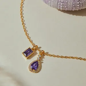 Close-up detail of luxury gold-plated necklace with sparkling purple zircon gemstone pendants.