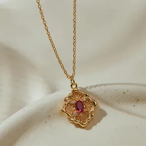 Collier pendentif floral ajouré doré vintage avec pierre rouge pour femmes élégantes.