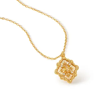 Exquisito collar con colgante floral dorado, intrincado grabado hueco y piedras brillantes.