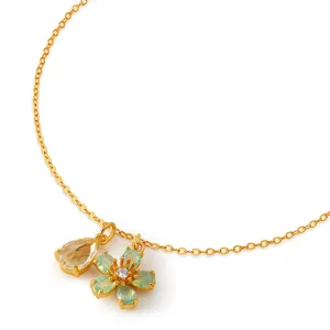 Detailed shot of gold plated brass necklace with teardrop and flower crystal pendants.