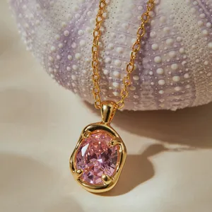 Gros plan detaille du collier dore elegante avec un pendentif en zircon rose scintillant.