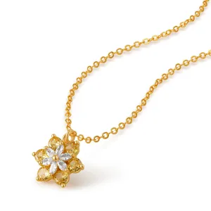 Primer plano de los detalles del collar floral dorado con circonitas amarillas y blancas.