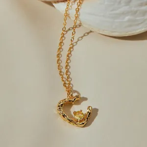 Elegante collar con colgante de circonita amarilla y cadena dorada de diseño único.