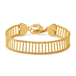Detalle de pulsera chapada en oro, diseño de barras verticales anchas, corazón y circonita.