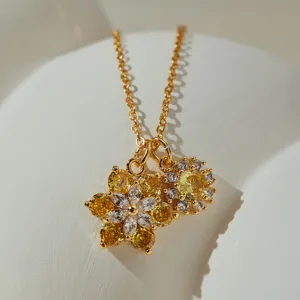 Delicate gold-tone flower pendant necklace with sparkling yellow and clear cubic zirconia stones.