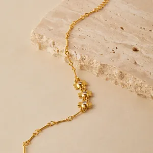 Primer plano detalle de pulsera de trébol circonita chapada en oro textura y piedras brillantes.