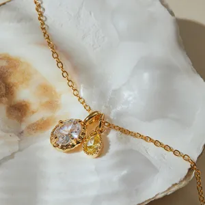 Exquisite gold necklace featuring dual oval and pear zircon pendants detail shot.