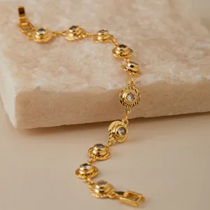 Primer plano detallado del brazalete de cadena de circón dorado con piedras brillantes.