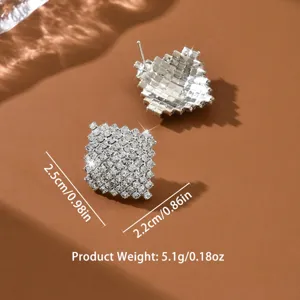 Primo piano dettagliato di orecchini geometrici in strass scintillanti e di ottima fattura.