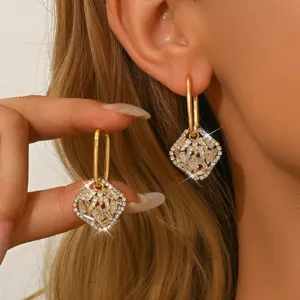 Eleganti orecchini geometrici con strass pavé e design dorato per un tocco chic.