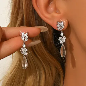Dettaglio orecchini pendenti con foglia in zircone scintillante, eleganti gioielli argento.