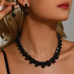 Exquisito juego de joyas de collar y pendientes de perlas negras y cristales vista detallada noche.