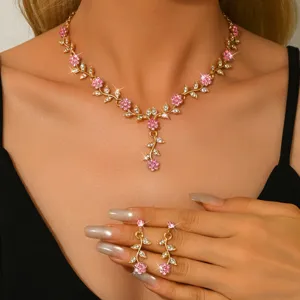 Vista detallada del conjunto de collar y pendientes florales de cristal dorado.