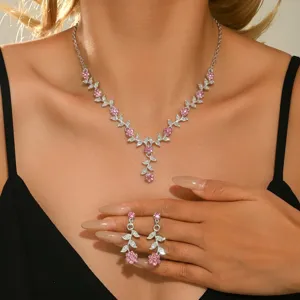 Primer plano detallado de collar floral de pedrería brillante y pendientes a juego.