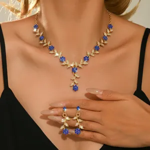 Detalle en primer plano del elegante collar floral de pedrería azul y pendientes.