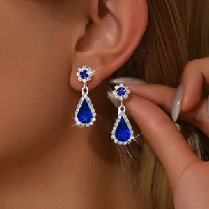 Exquisitos pendientes de cristal azul en forma de gota con brillantes pedrería y diseño floral.
